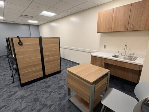 Lab room 1218 with 8 computer desks and a sink